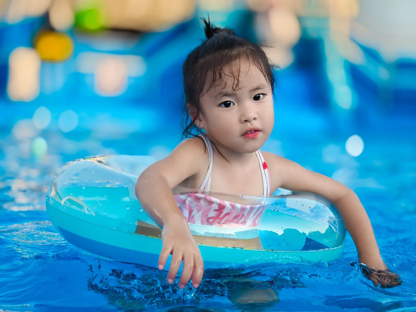 Gia đình châu Á nghỉ ngơi trong lịch trình vui chơi công viên nước