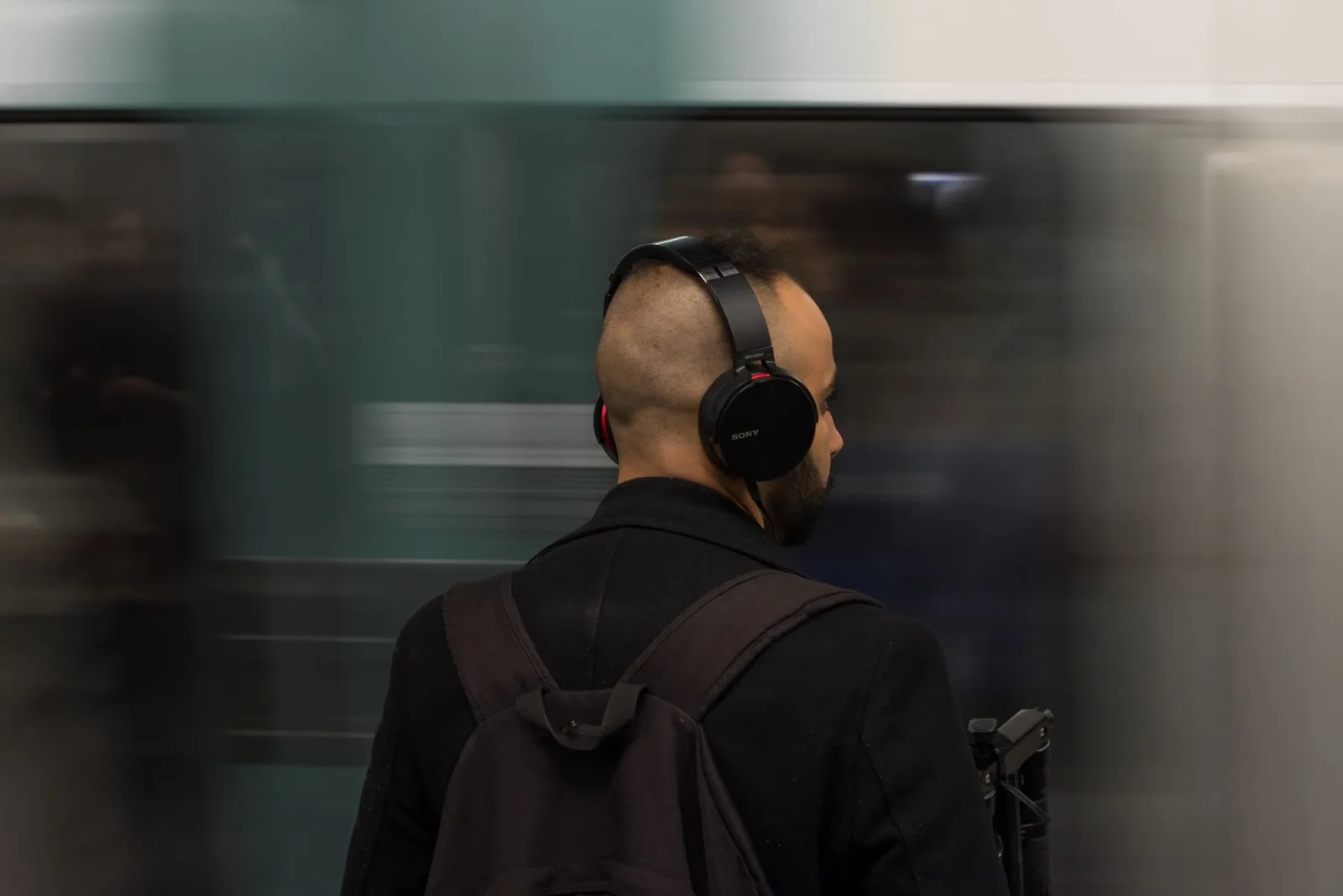 Người trẻ nghe audio bằng tai nghe khi di chuyển