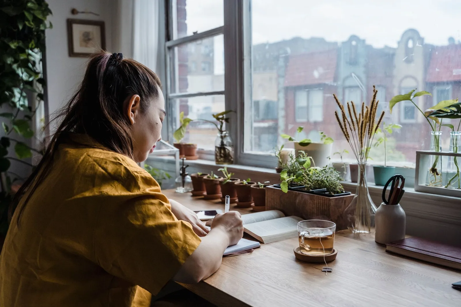 Cô gái trẻ ghi chép vào sổ tay bên cạnh màn hình máy tính