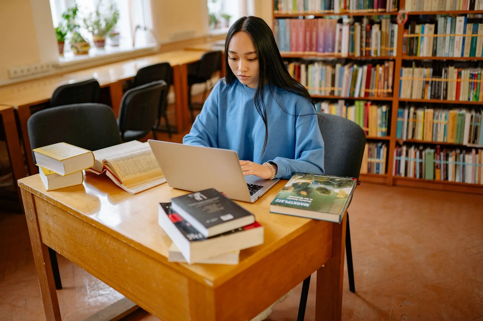 Sinh viên châu Á làm bài trên laptop lúc nửa đêm