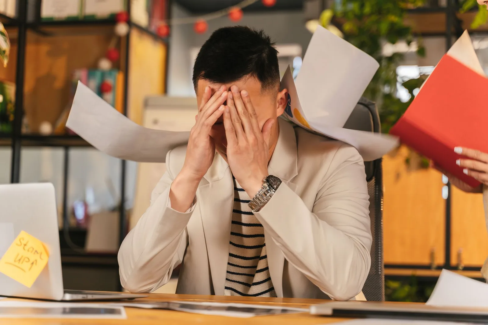 Người lớn châu Á mất tập trung bên bàn làm việc
