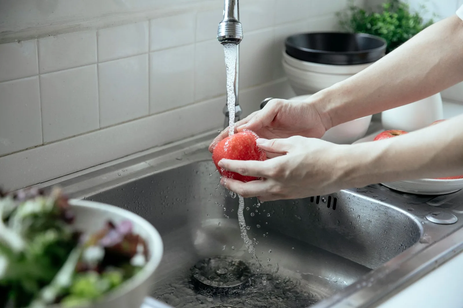 Trái cây tươi được rửa kỹ dưới vòi nước