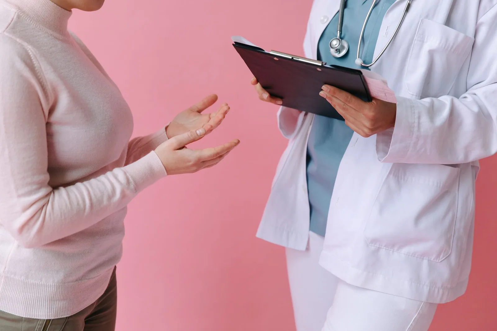 Bệnh nhân châu Á trao đổi với bác sĩ tại phòng khám