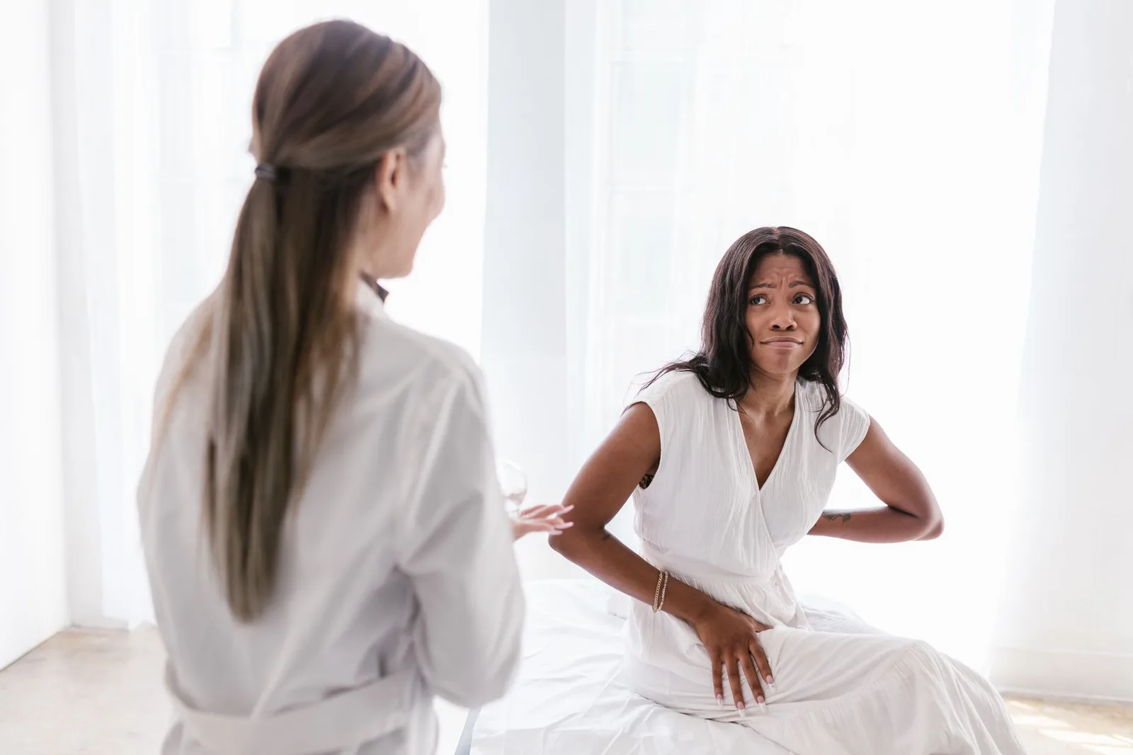 Bệnh nhân châu Á trao đổi với bác sĩ về triệu chứng đau dạ dày