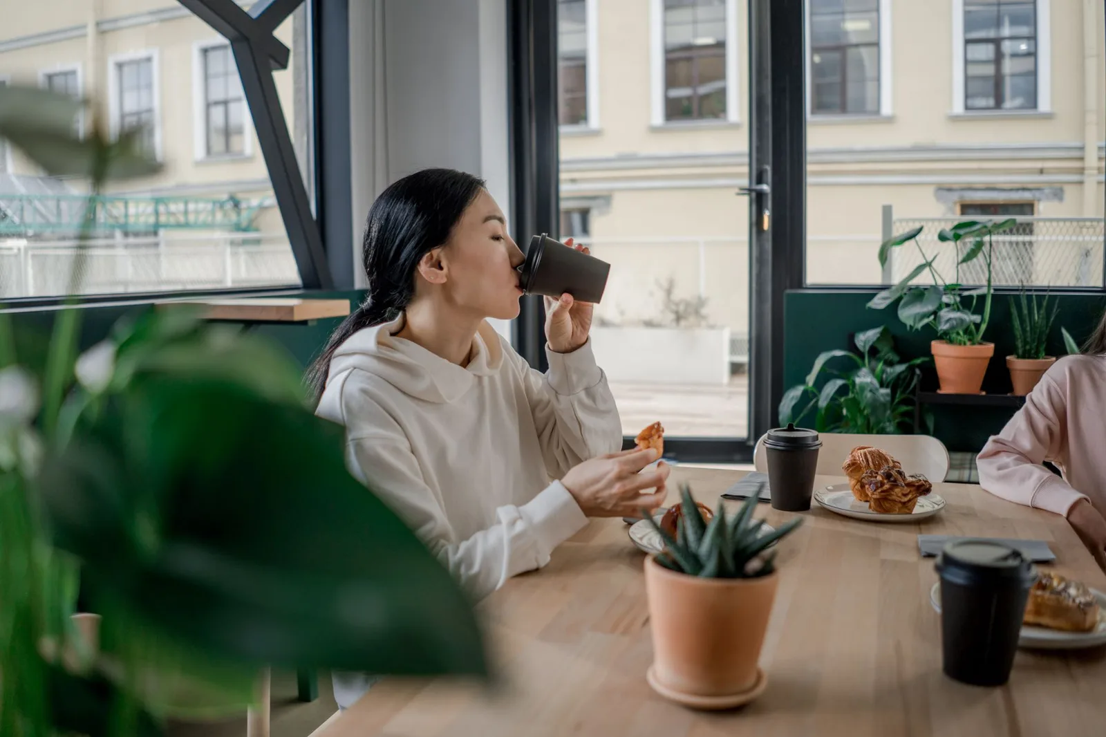 Người phụ nữ châu Á cảm thấy ợ chua sau khi uống cà phê buổi sáng
