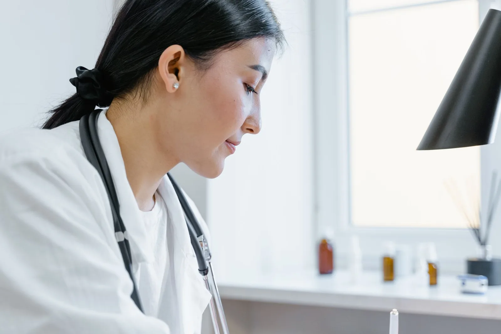 Bác sĩ kê đơn thuốc cho bệnh nhân châu Á