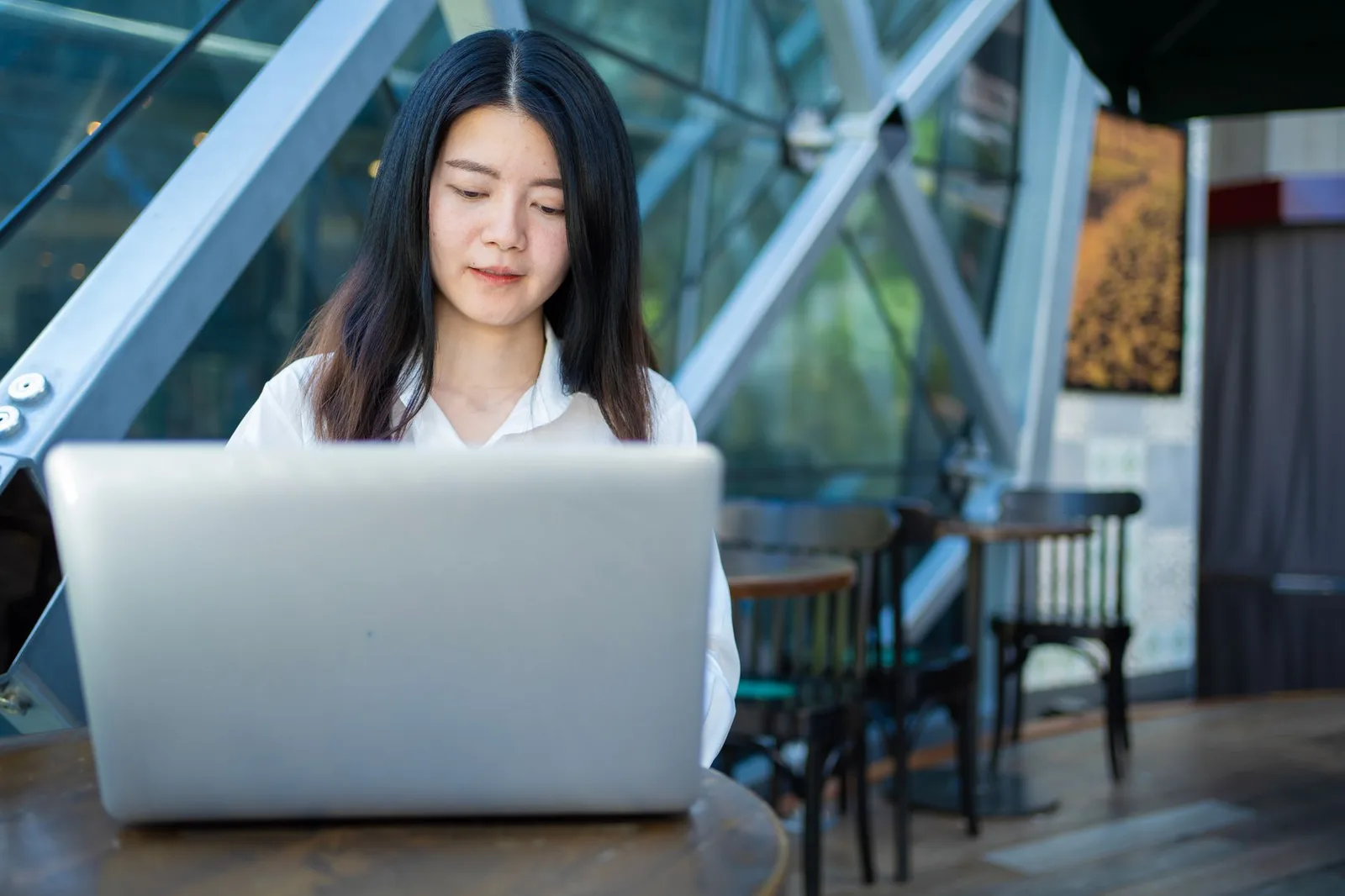 Người trẻ châu Á làm việc với laptop trong quán cà phê đêm khuya