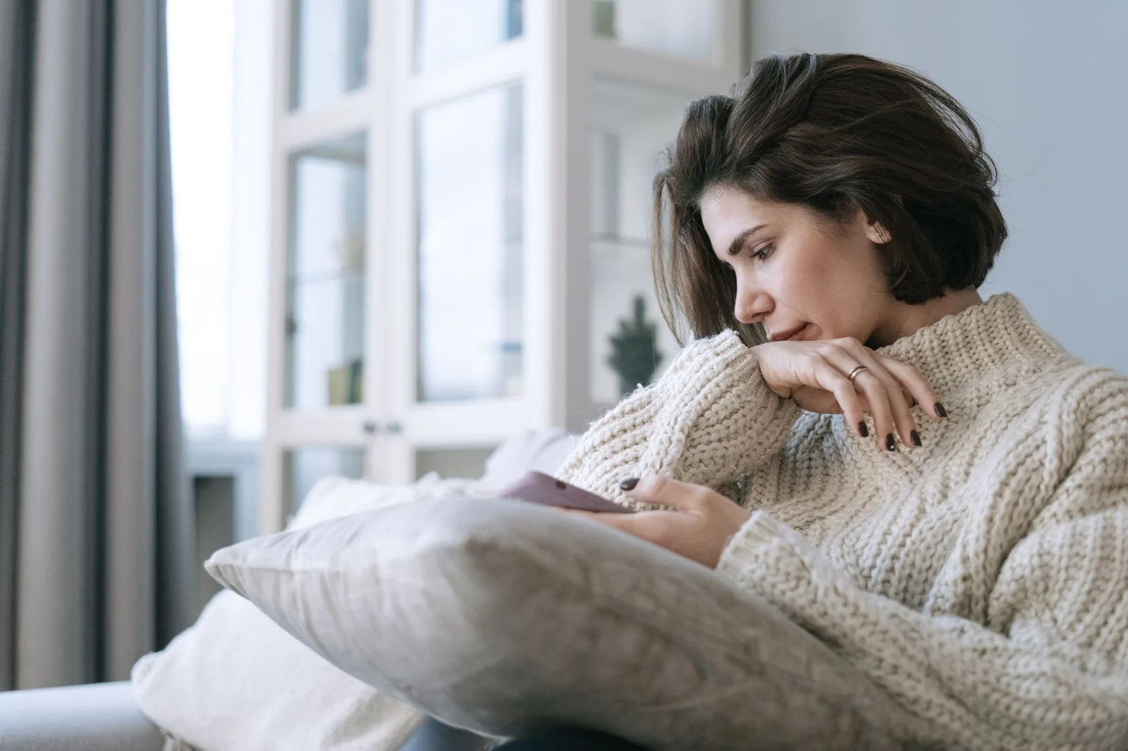Cô gái châu Á buồn bã kiểm tra điện thoại khi ở một mình
