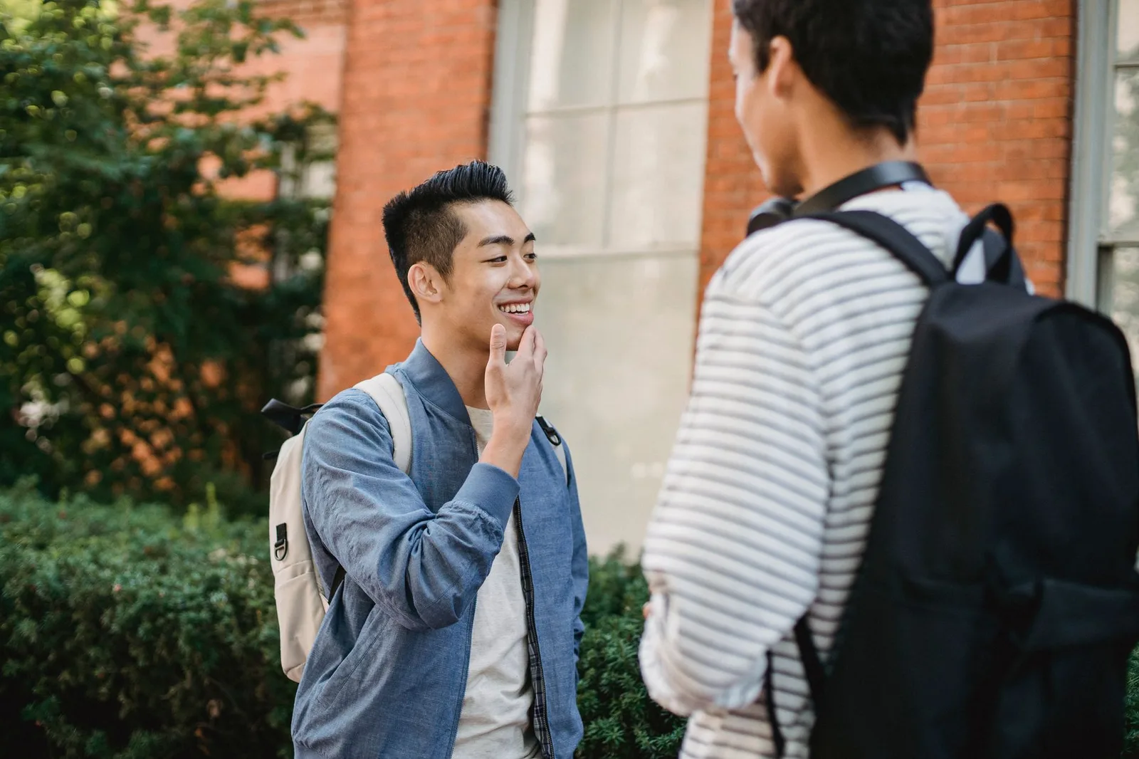 Hai người châu Á bình tĩnh nói lời tạm biệt ngoài trời
