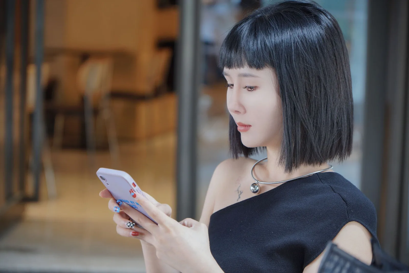 Người phụ nữ châu Á thận trọng kiểm tra điện thoại