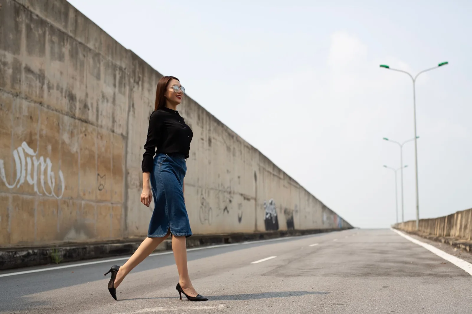 Người phụ nữ châu Á bước đi một mình trên con đường lúc hoàng hôn