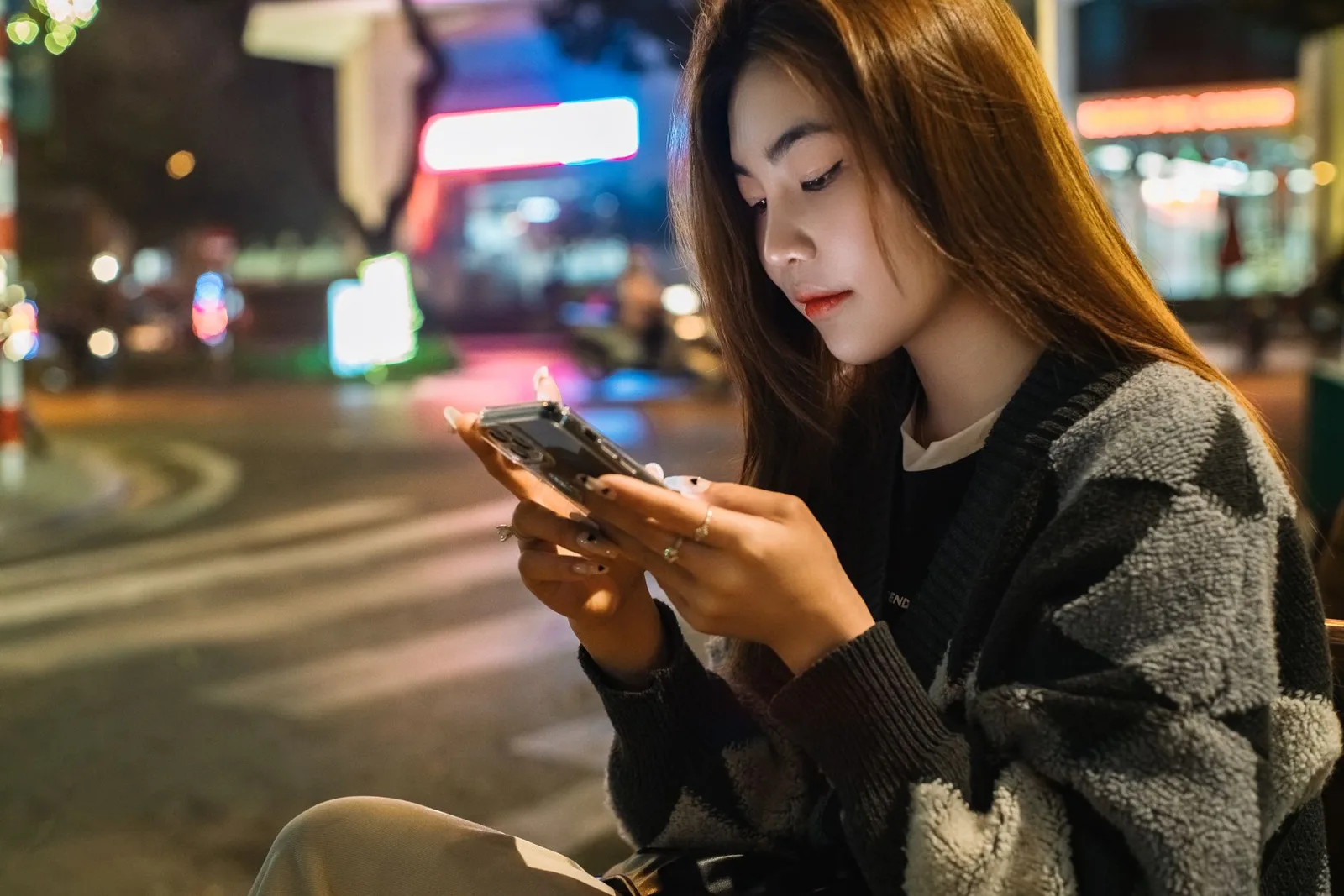 Nữ du khách kiểm tra điện thoại trên đường ven biển