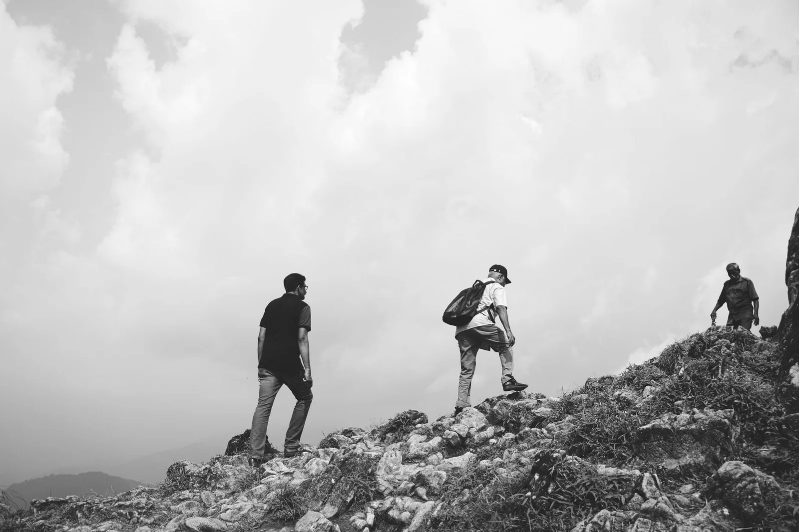 Nhóm người châu Á hỗ trợ nhau khi trekking đường núi