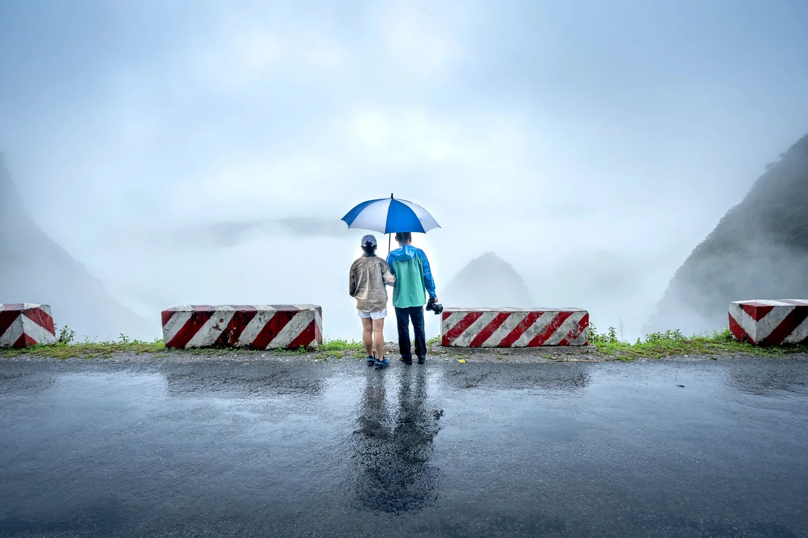 Người đi xe máy mặc áo mưa kiểm tra trước chặng đường núi
