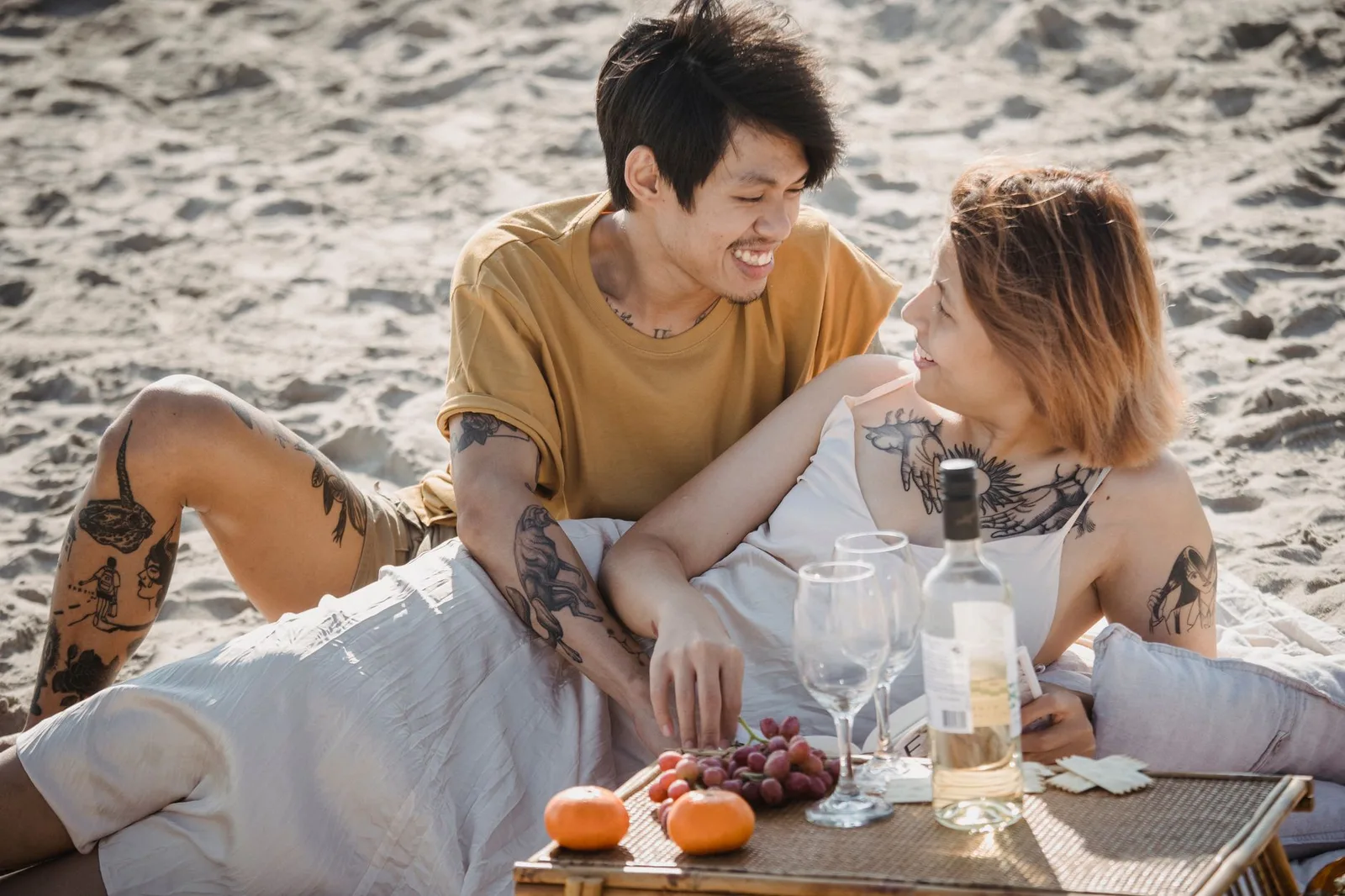 Cặp đôi châu Á tận hưởng buổi picnic ngắm hoàng hôn bên biển