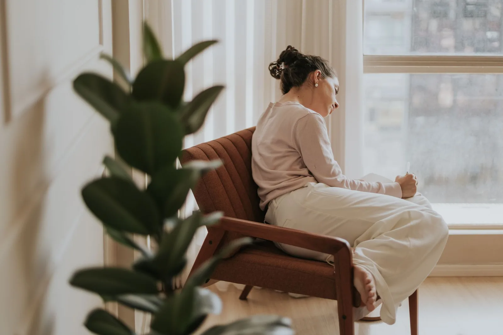 Du khách châu Á viết nhật ký và tự vấn bên cửa sổ