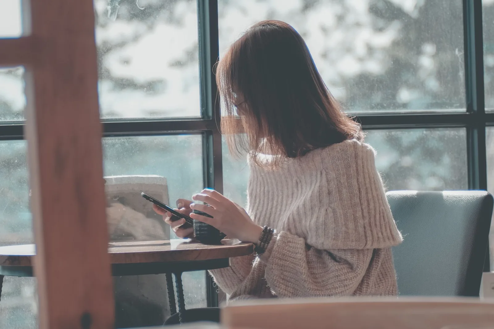 Người phụ nữ châu Á viết nhật ký và đặt điện thoại sang một bên