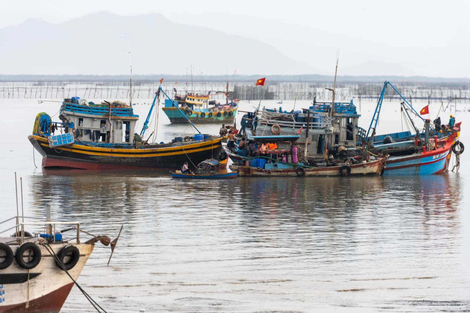 Ngư dân chuẩn bị thuyền và dụng cụ trước khi rời bờ