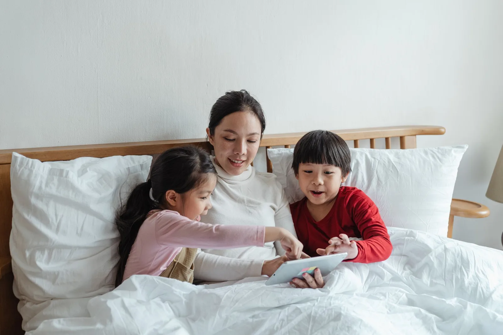 Trẻ em châu Á vui chơi bên cạnh máy tính bảng