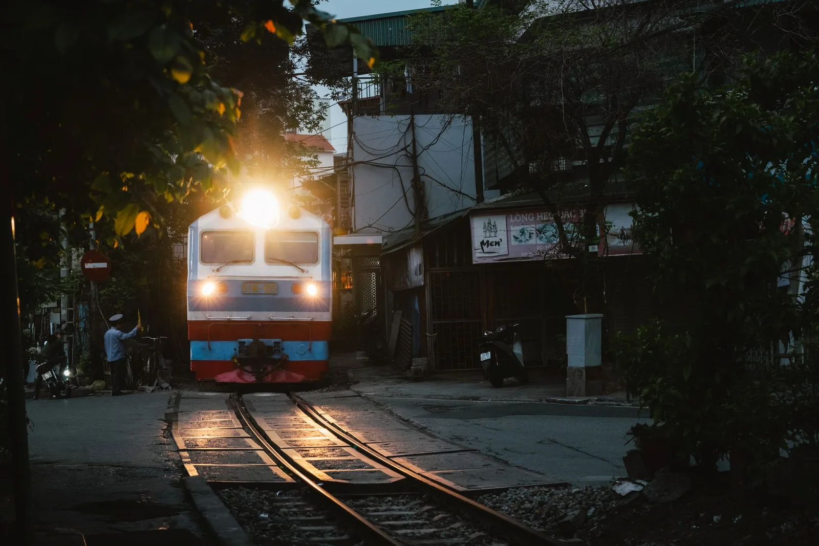 Đoàn tàu đi qua con phố hẹp tại Hà Nội