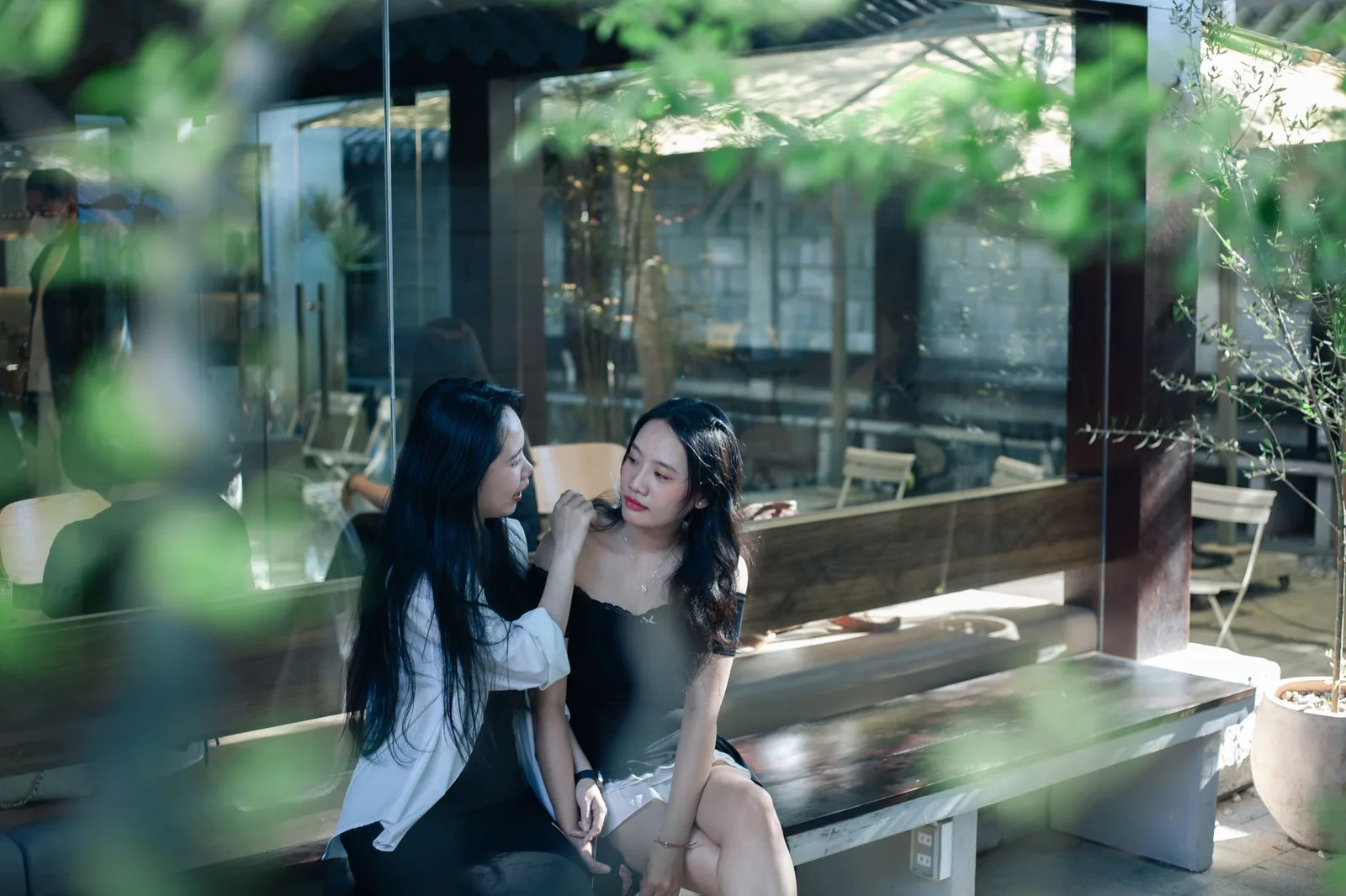 Hai người bạn trò chuyện trầm lắng trong quán cà phê