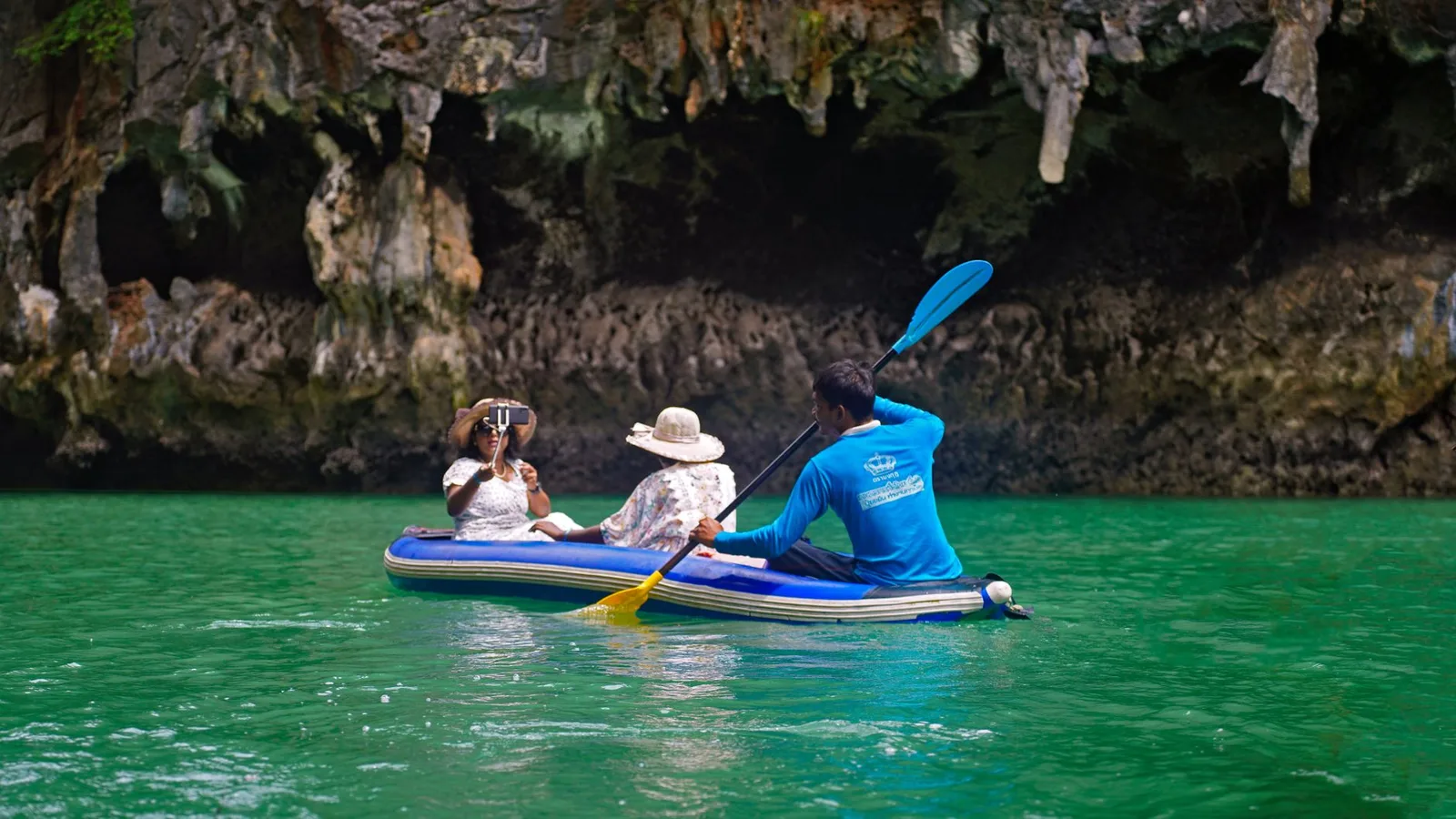 Cặp đôi châu Á chèo kayak giữa vịnh đá vôi