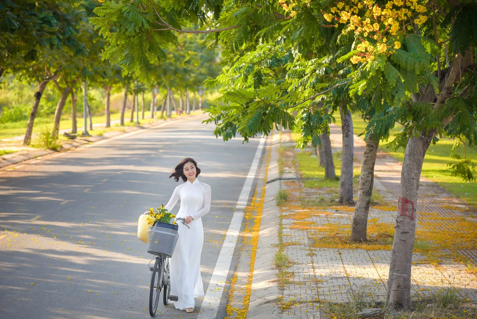Du khách châu Á đạp xe trên phố hoa vào buổi sáng