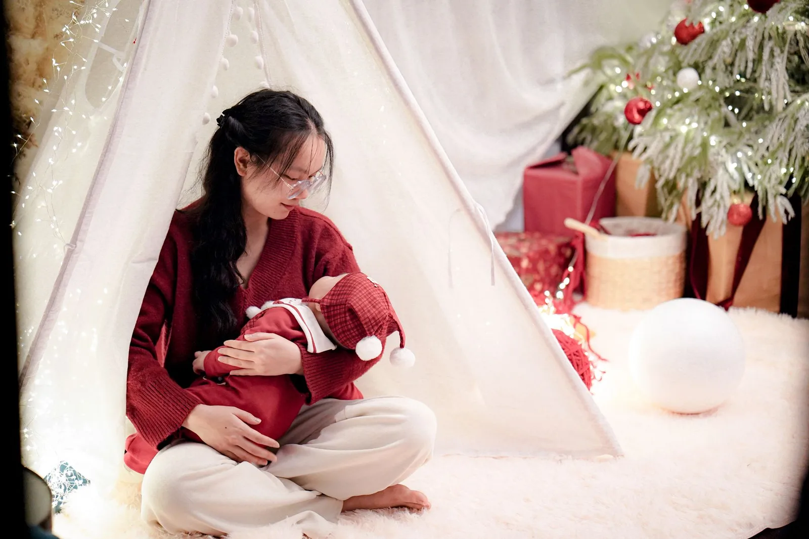 Người mẹ ôm bé gái trong không gian ấm cúng