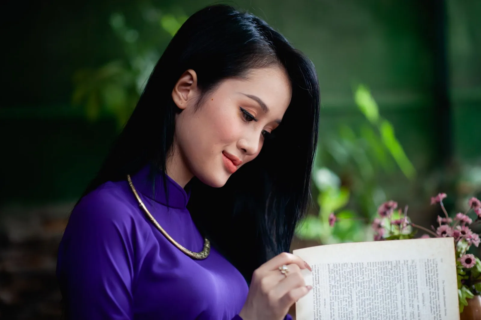 Thiếu nữ Việt Nam mặc trang phục truyền thống và đọc sách