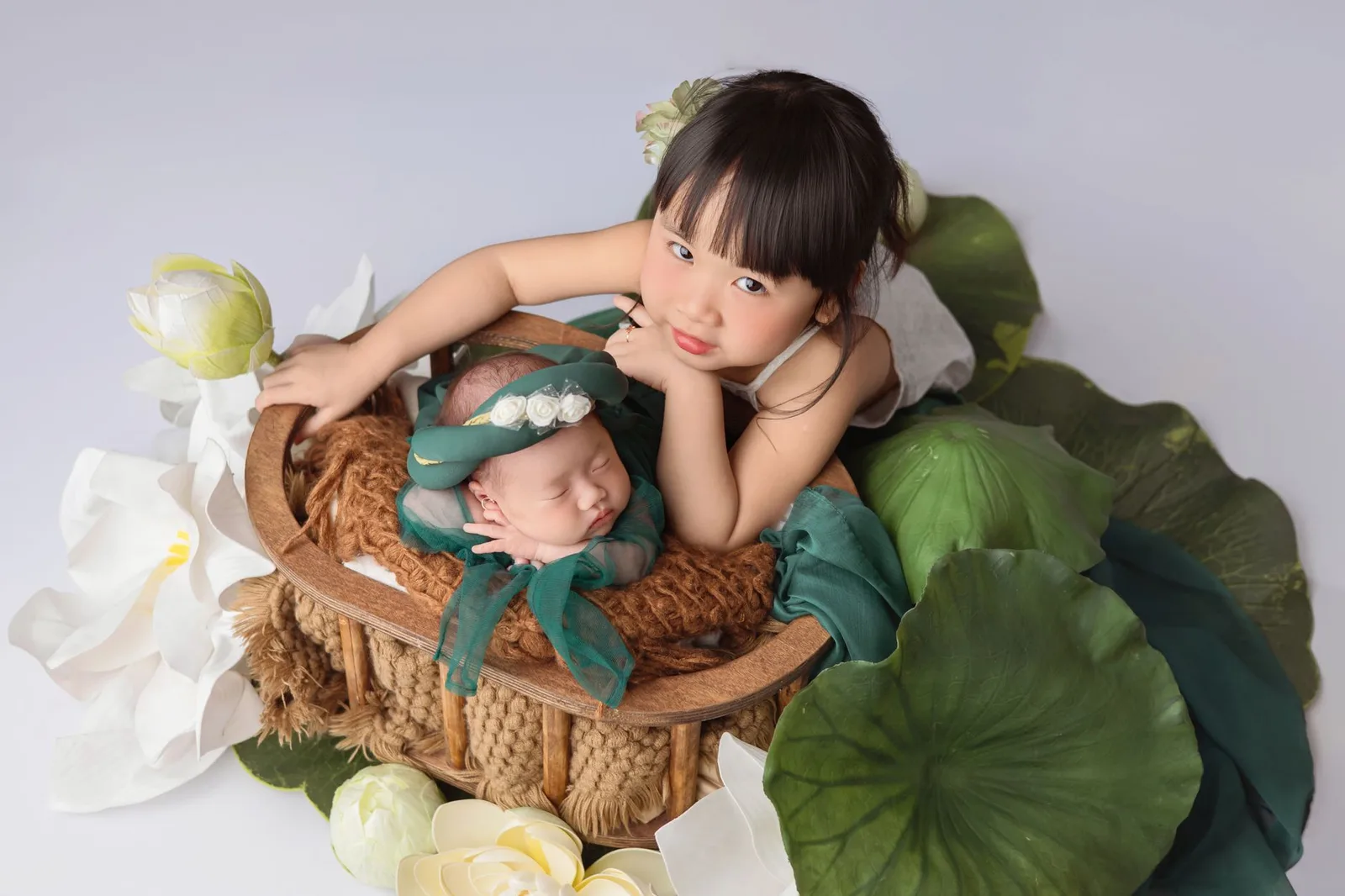 Anh chị âu yếm em trai sơ sinh trong vòng tay