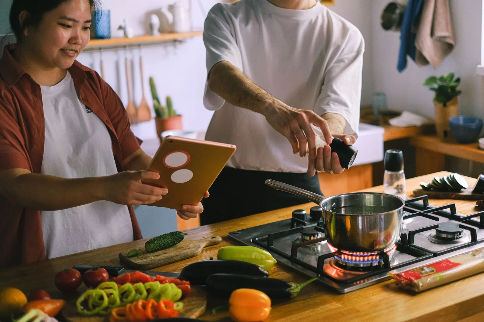 Cặp đôi châu Á cùng nấu ăn trong căn bếp ấm cúng