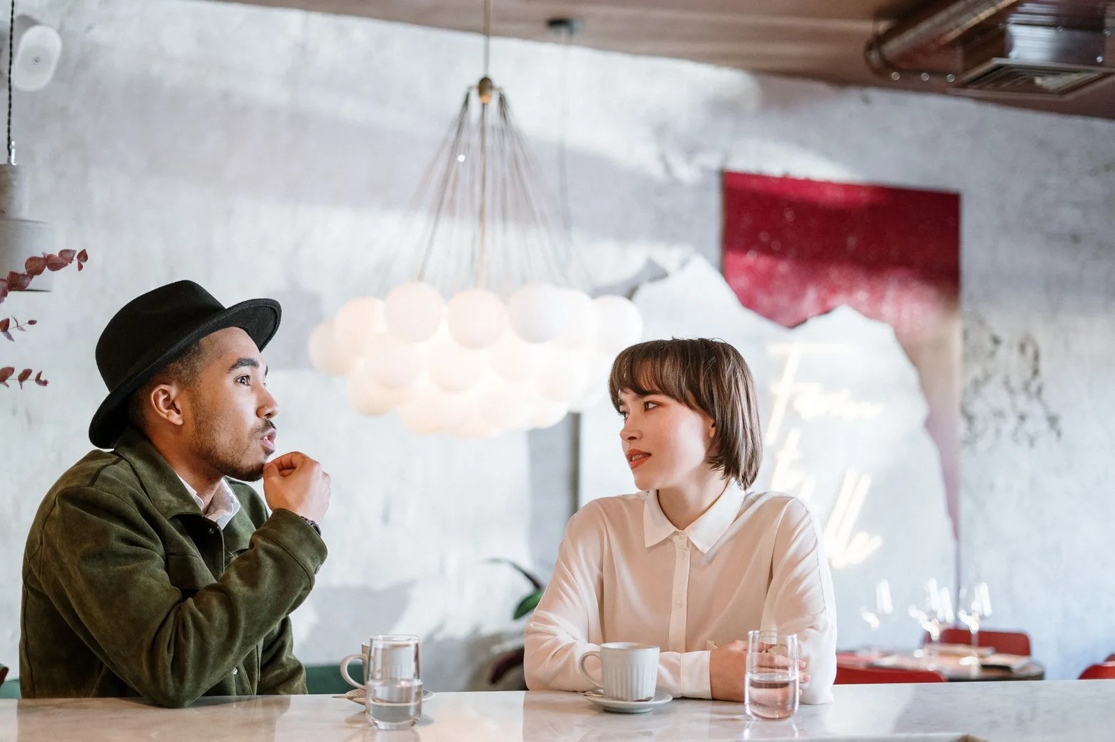 Cặp đôi châu Á chân thành chia sẻ cảm xúc trong quán cà phê
