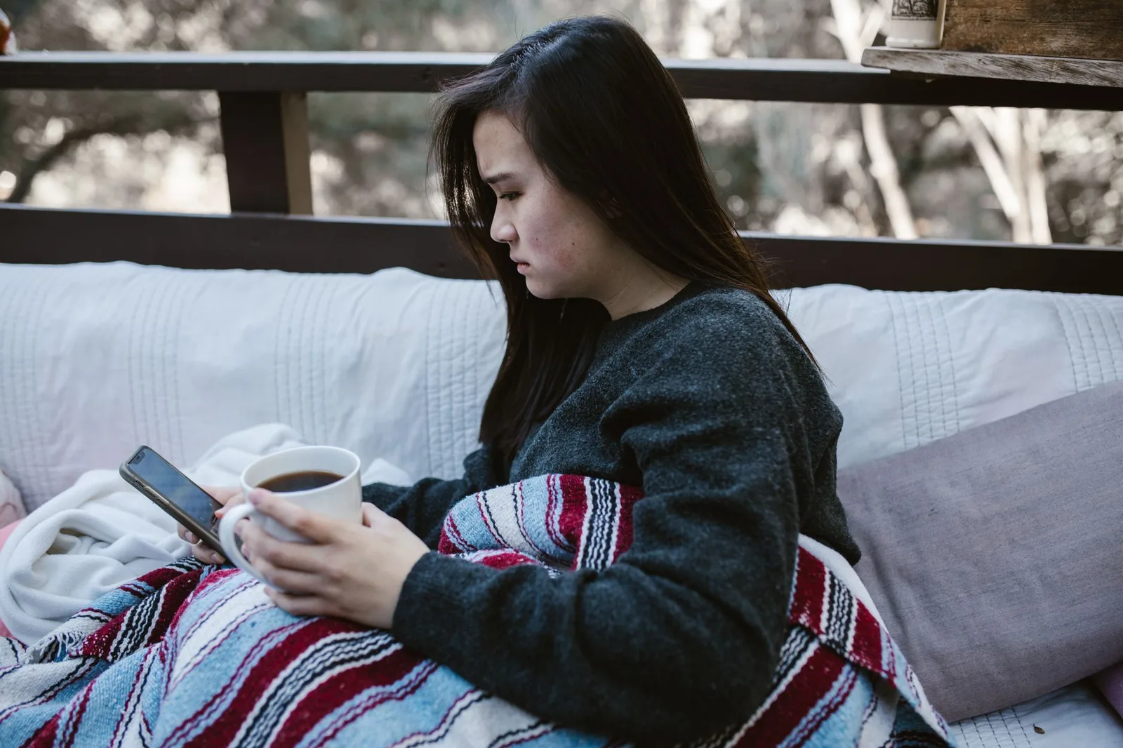 Du khách châu Á kiểm tra thông tin homestay trên điện thoại