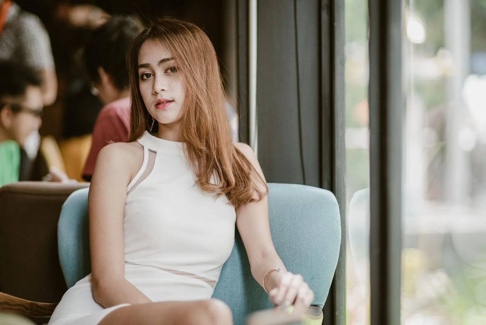 Cô gái châu Á tạo dáng bên cửa sổ ngập ánh sáng tự nhiên