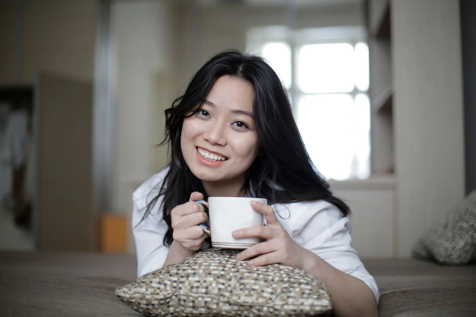 Người phụ nữ châu Á nhâm nhi cà phê ngoài trời buổi sáng