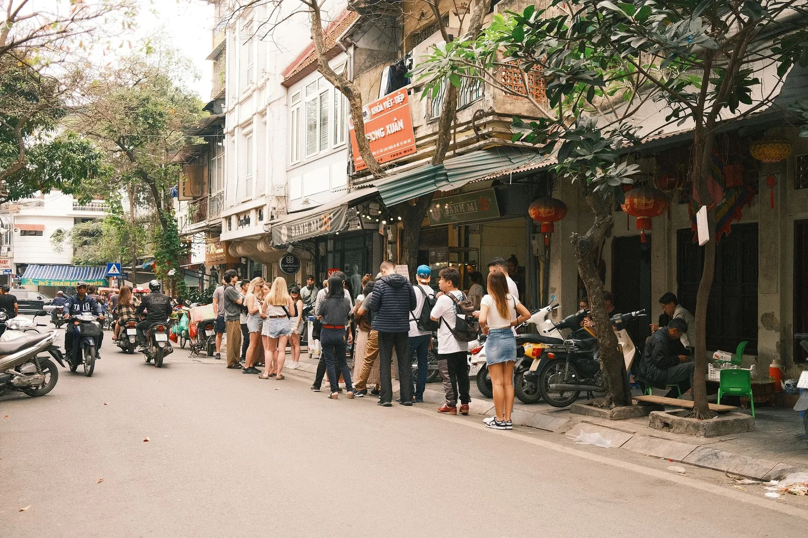 Du khách châu Á thử cà phê Việt vỉa hè