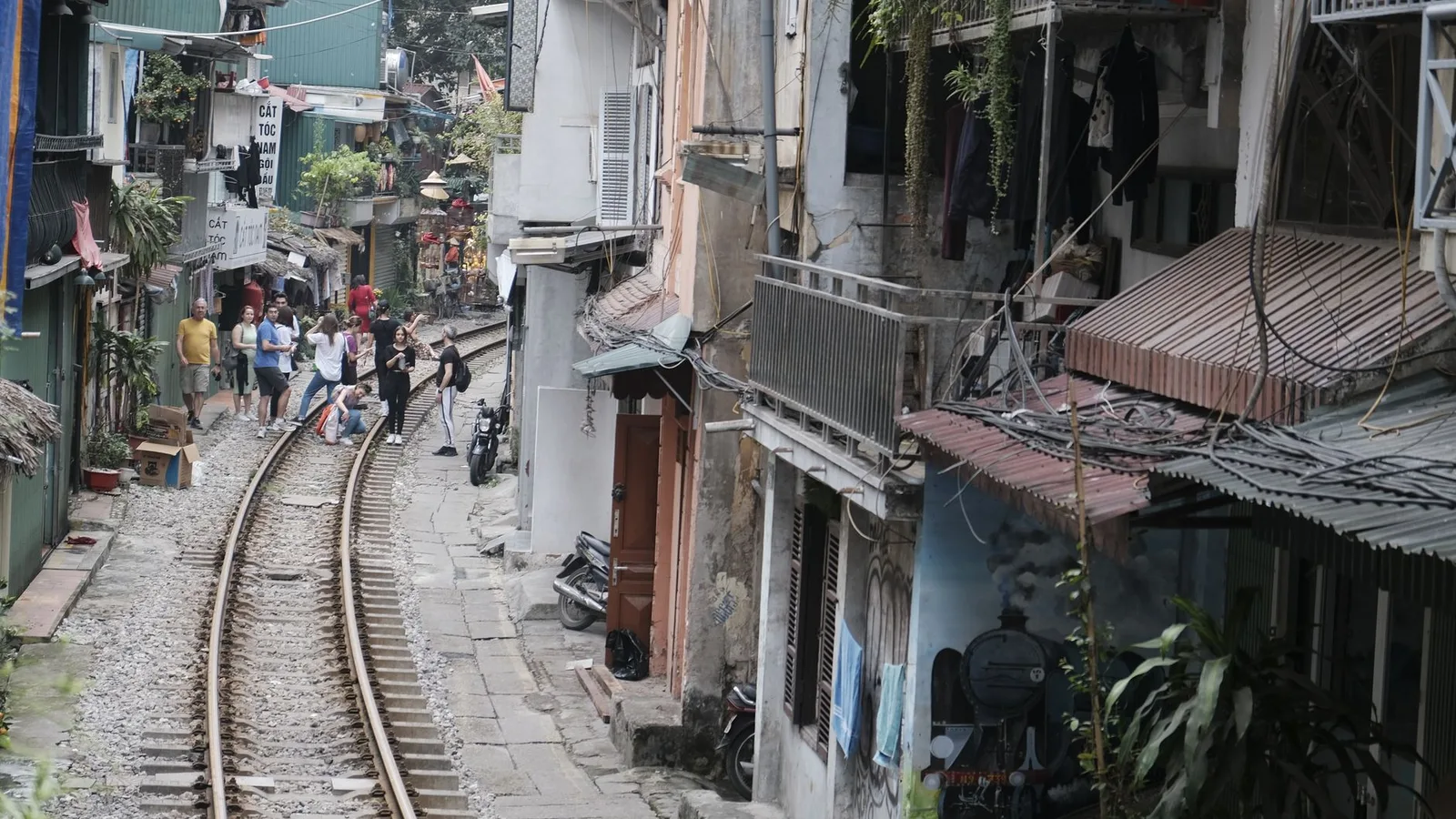 Du khách quan sát phố cà phê đường tàu từ khoảng cách an toàn