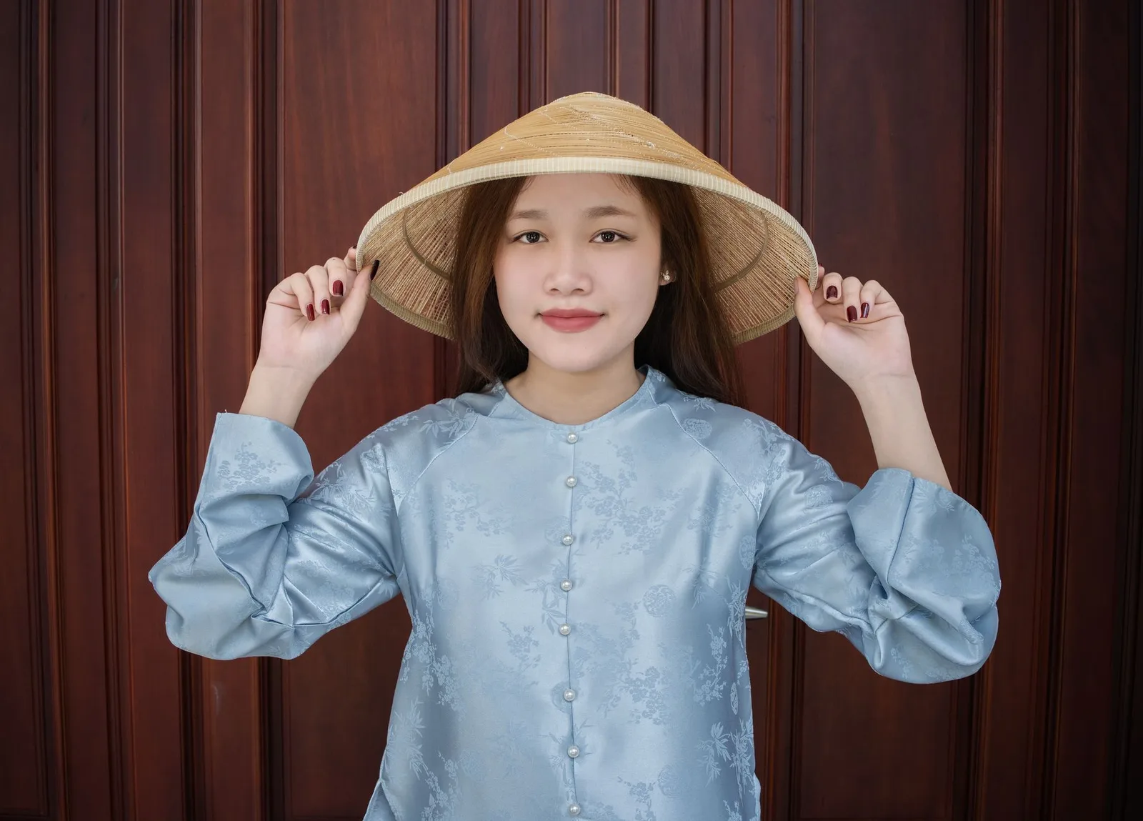 Người phụ nữ Việt Nam thử áo lụa trước khi nhận