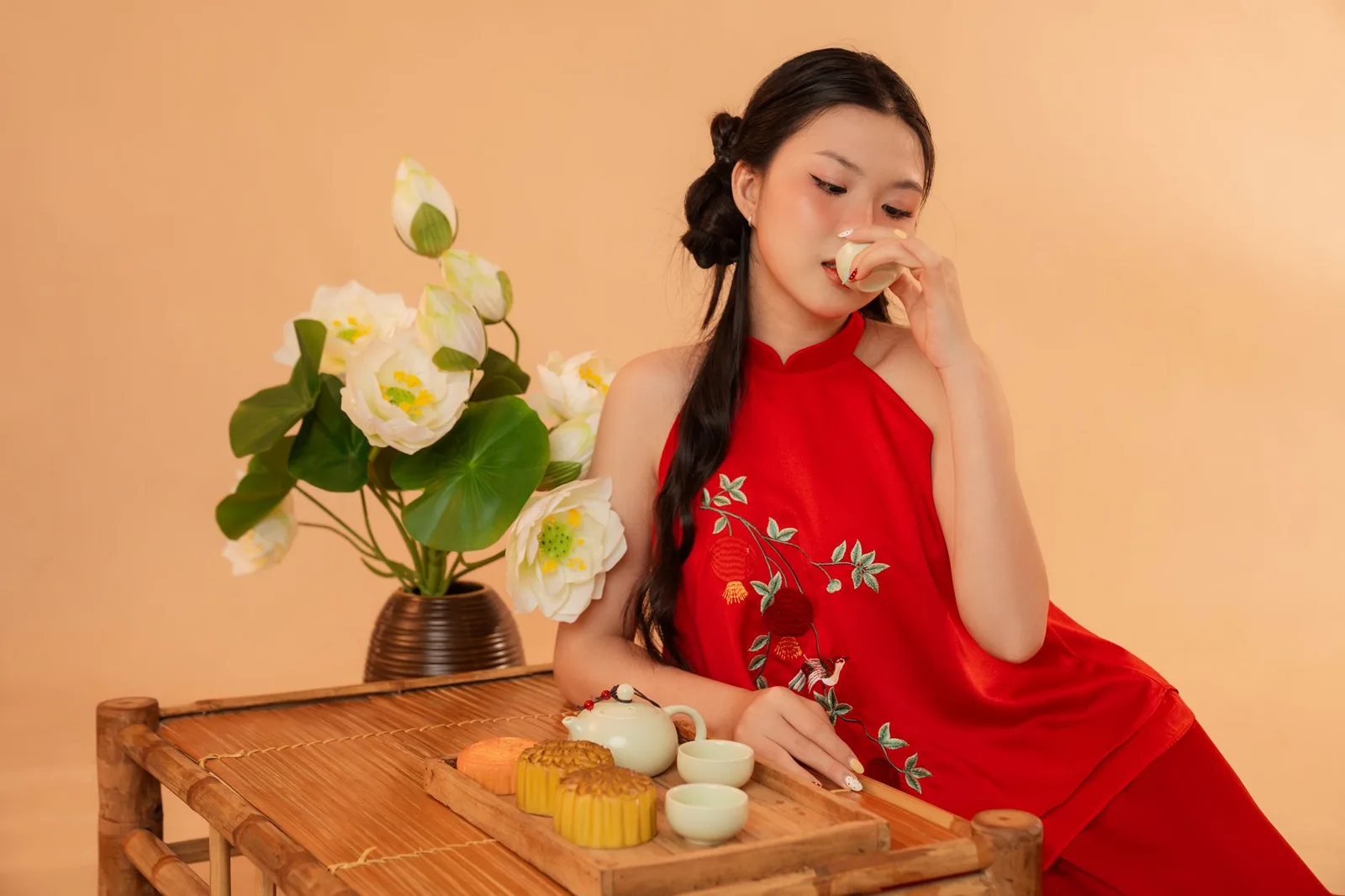 Người châu Á chia sẻ miếng bánh Trung thu nhỏ cùng trà