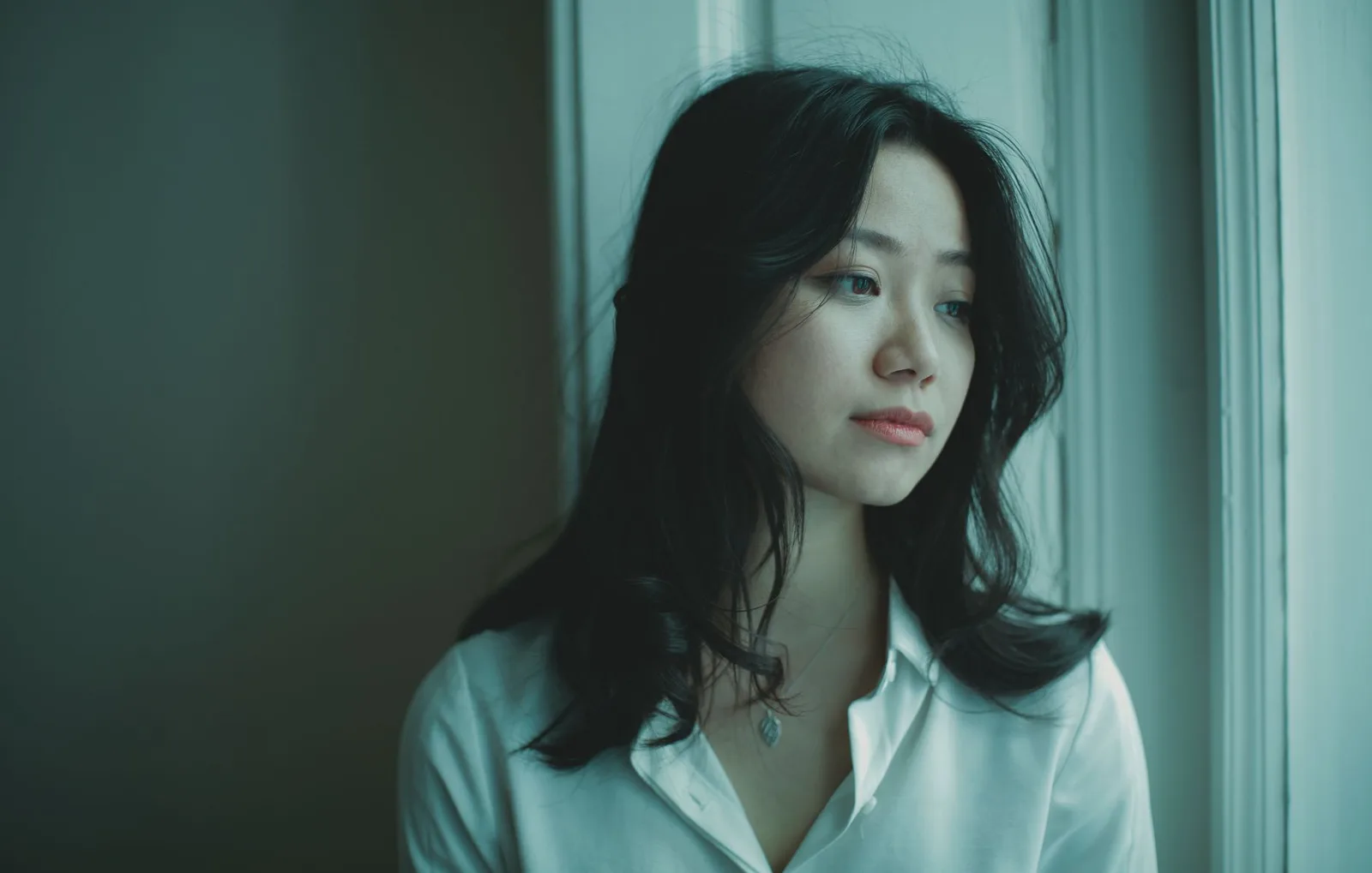 Người phụ nữ châu Á suy ngẫm bên cửa sổ