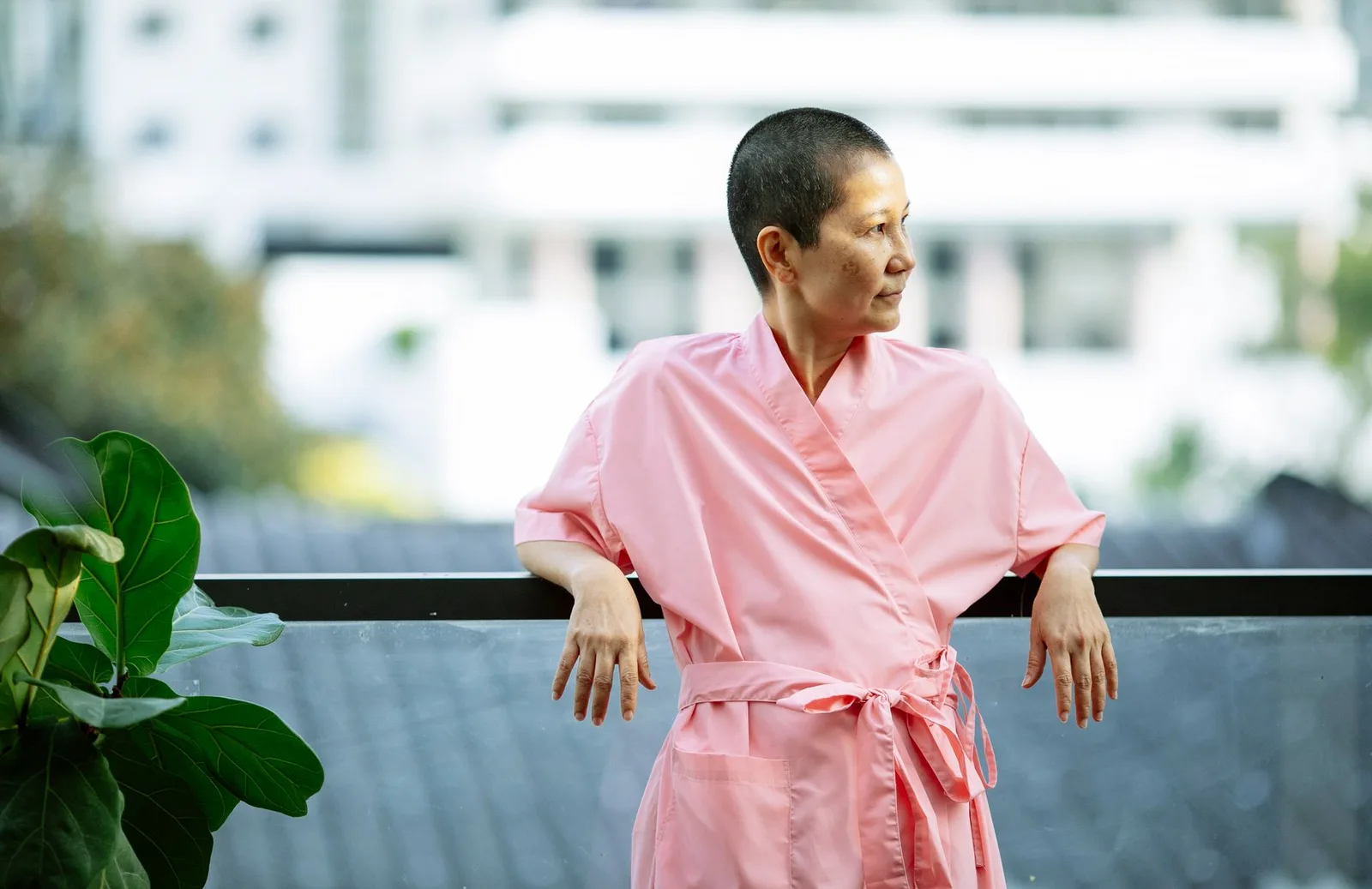 Người phụ nữ châu Á thư thái trên ban công vào buổi sáng