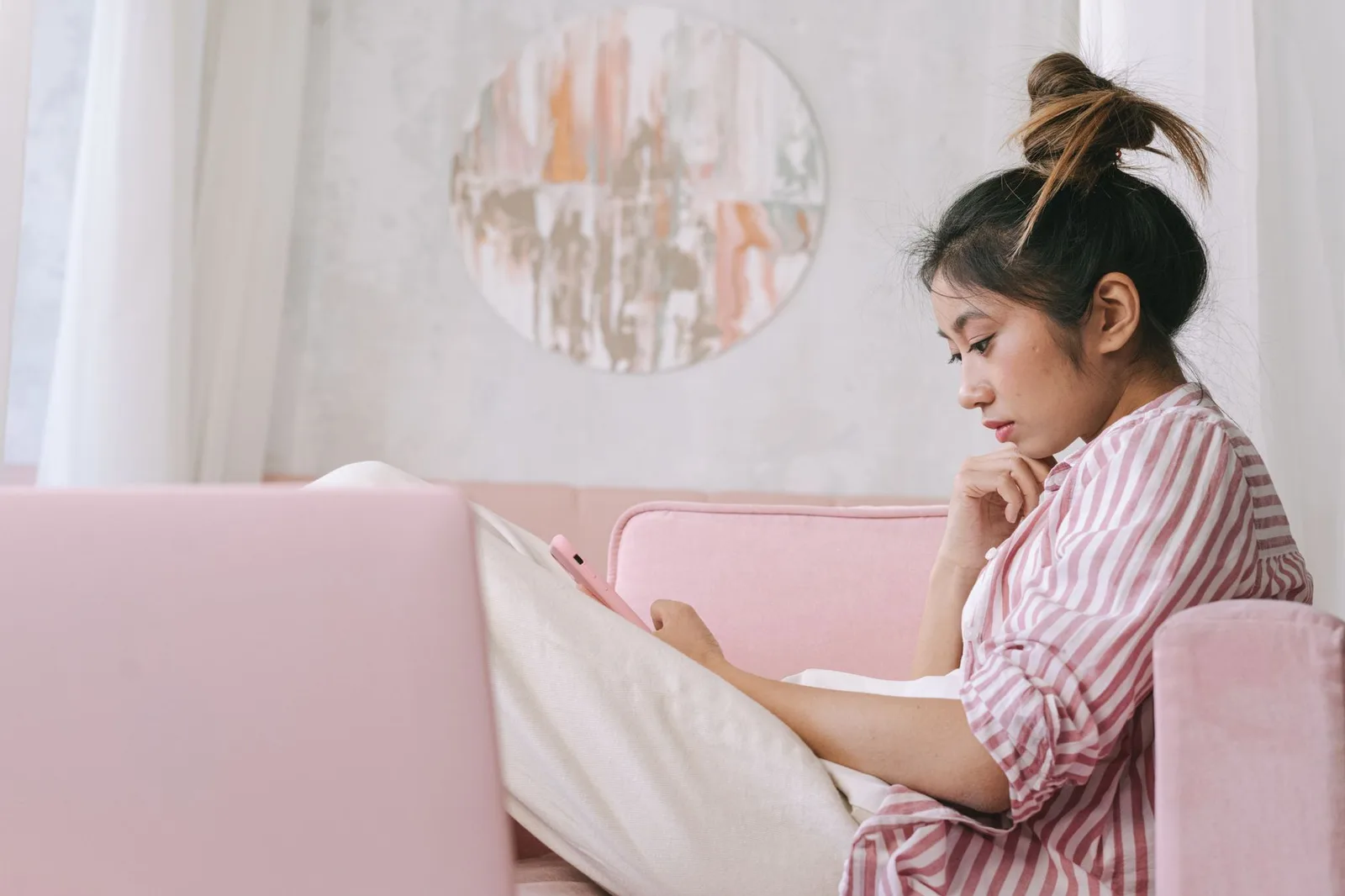 Cô gái châu Á suy nghĩ khi soạn tin nhắn tại nhà