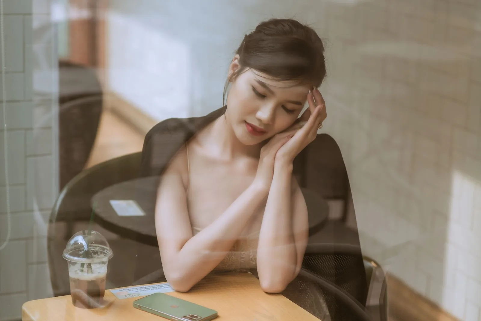 Người phụ nữ châu Á thư giãn bên cửa sổ mà không tự trách