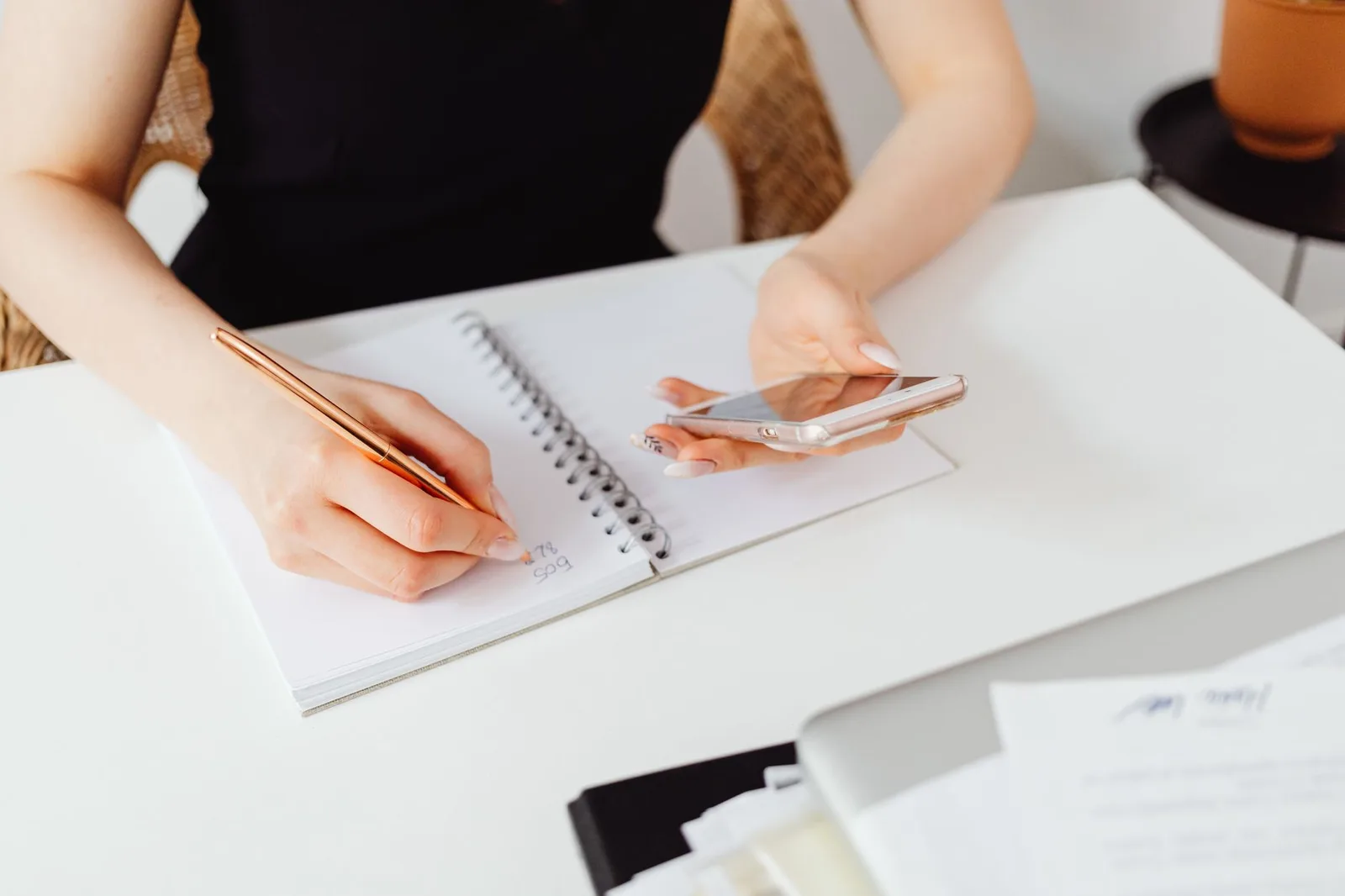 Người phụ nữ ghi lại suy nghĩ bên cạnh điện thoại