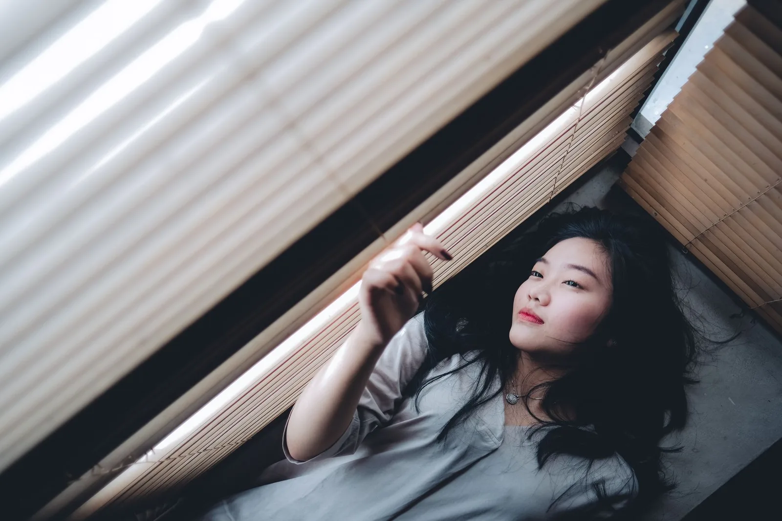 Người phụ nữ châu Á suy ngẫm về cảm xúc bên cửa sổ