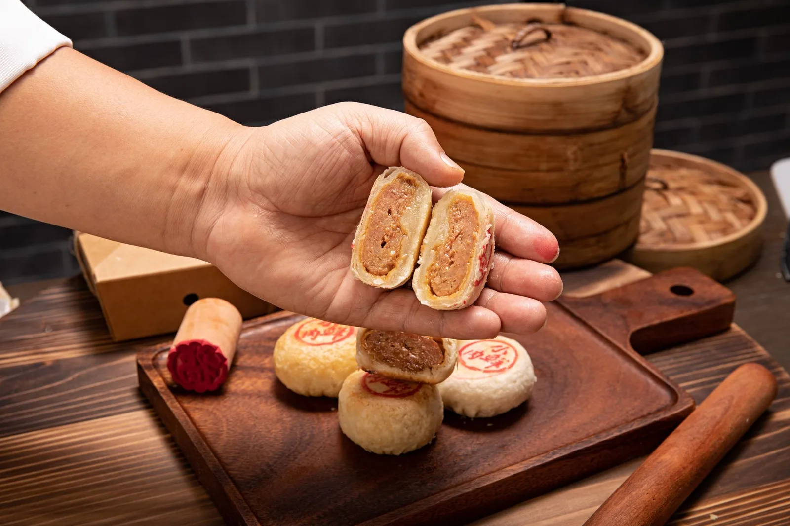 Bàn tay đang bày bánh trung thu và trái cây lên mâm cỗ
