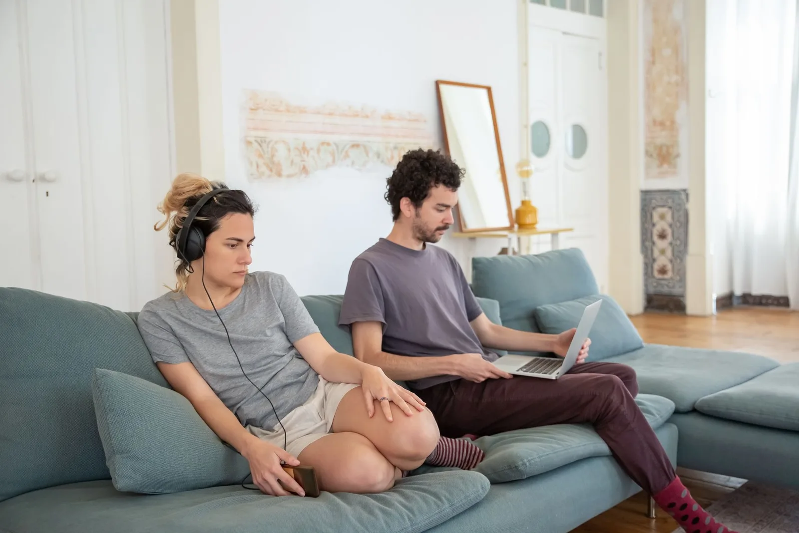 Cặp đôi ngồi cách xa nhau trong phòng khách